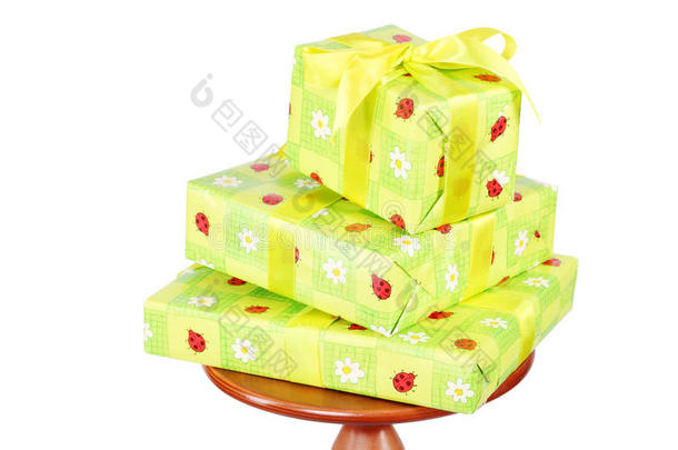 三个绿色礼品盒放在小圆桌上