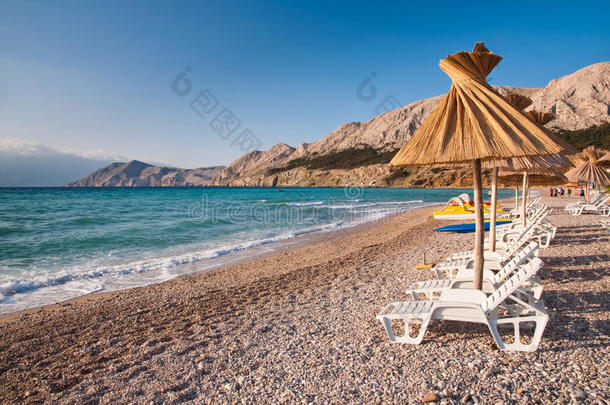 克罗地亚巴斯卡海滩上的遮阳伞和躺椅