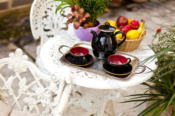<strong>花</strong>园里有<strong>茶具</strong>和水果的老式桌子