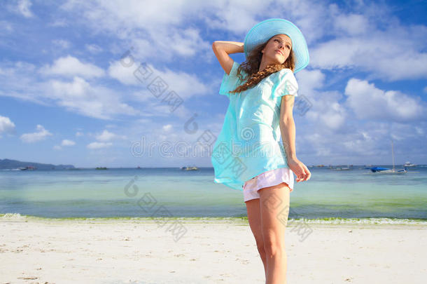 热带海洋背景下戴帽子的微笑少女