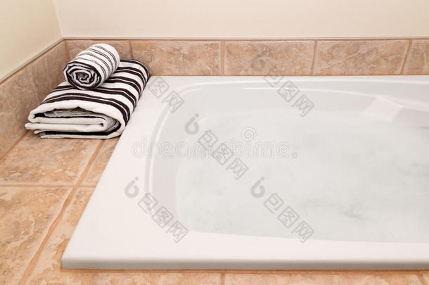 折叠条纹毛巾和泡沫浴缸