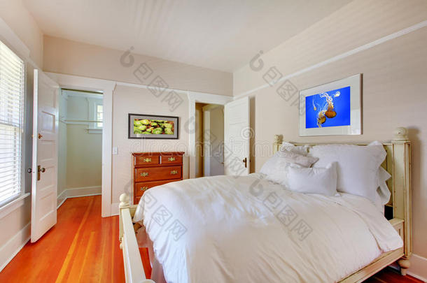 卧室有白色的床和樱桃木地板。