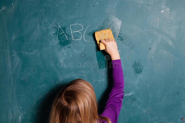 小女孩用湿海绵擦黑板