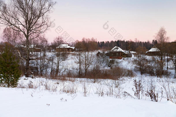 粉红色的冬日日落在乡村的房子下面