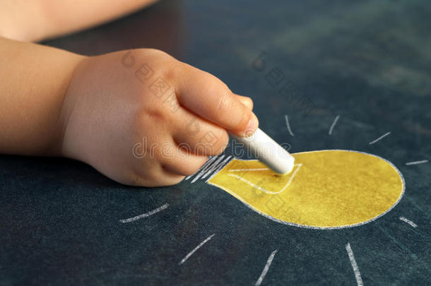 婴儿画灯泡的手。
