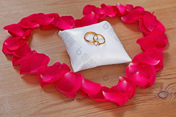 结婚戒指和一颗红玫瑰瓣的心
