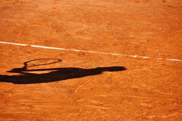 泥网球场上的网球运动员影子