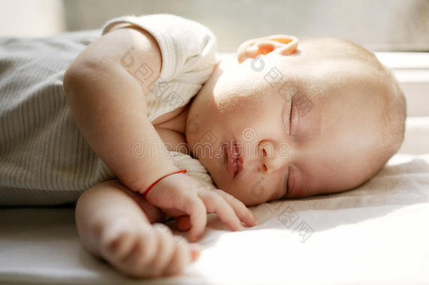 婴儿睡在窗户上的白色毯子