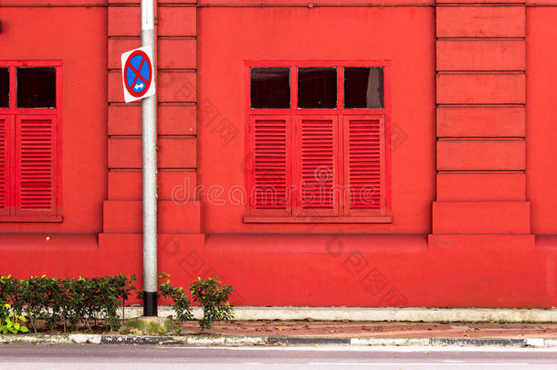 背景：红色的建筑物旁边有交通标志。