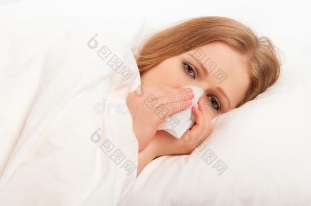 生病的女孩在床上对着手帕打喷嚏