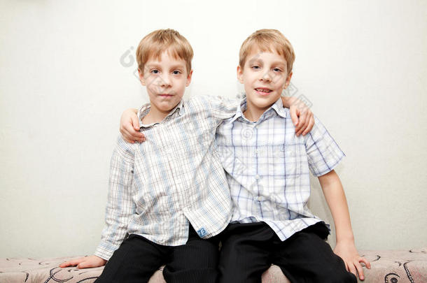 两个双胞胎兄弟拥抱着，微笑着。