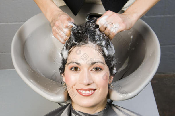 有吸引力的女人得到水疗沙龙洗发水和调理