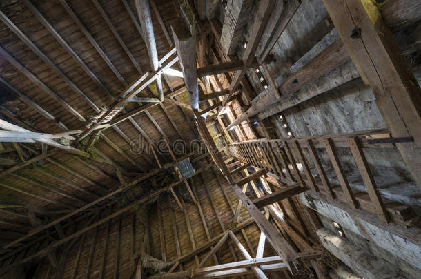 旧的木制谷仓屋顶，光线透过木板照射进来