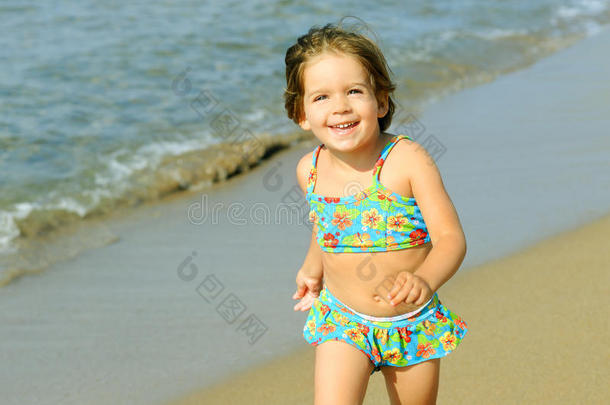 快乐的小女孩在沙滩上奔跑