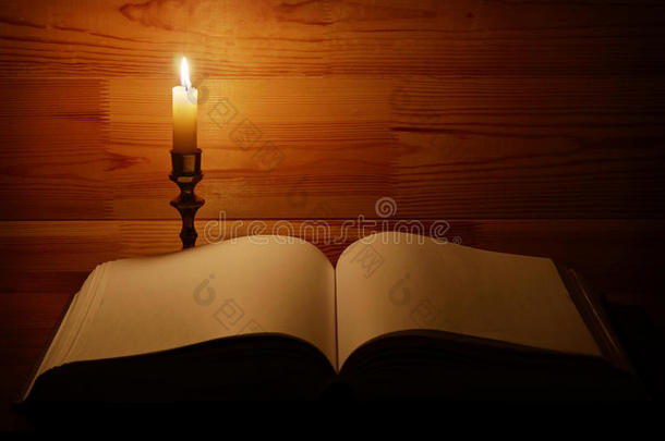 在翻开的旧书旁点着蜡烛