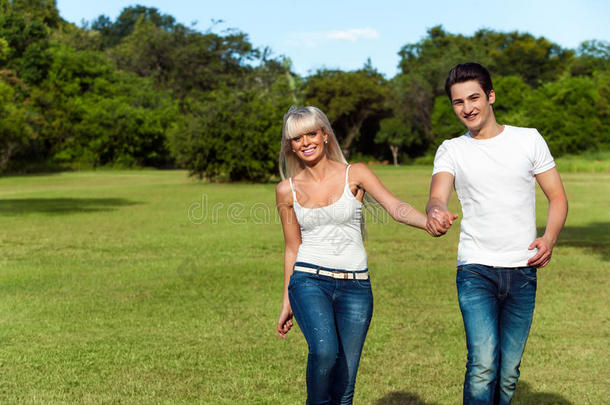 一对年轻夫妇在公园里<strong>蹦蹦</strong>跳跳。