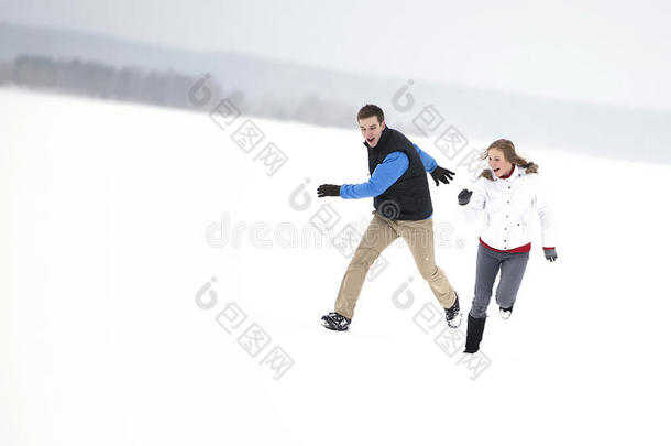 一对年轻快乐的夫妇在<strong>雪地里奔跑</strong>