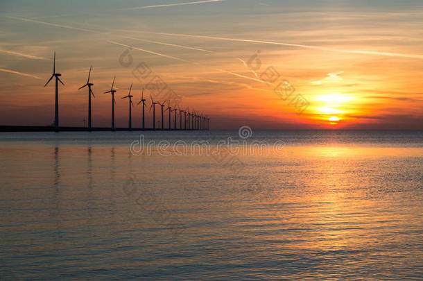 一排<strong>长长</strong>的风力涡轮机，日落在海面上
