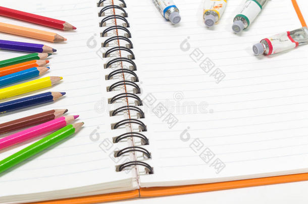 粉<strong>红橙</strong>色笔记本和彩色铅笔的特写镜头，水彩