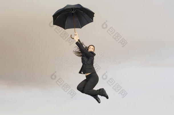 空中撑伞的女商人