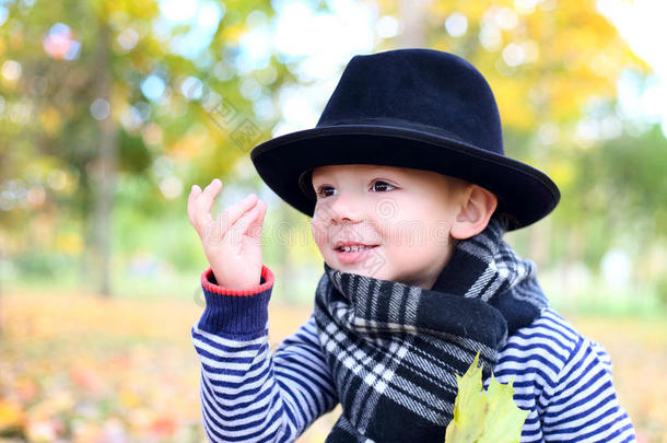 秋天公园里戴黑帽子的可爱小绅士