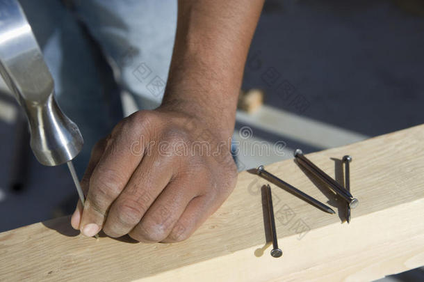 工人把钉子钉在木板上