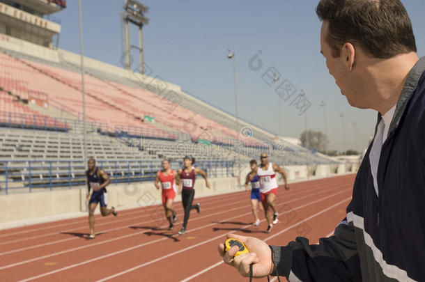 运动员在跑道上比赛时带秒表的教练