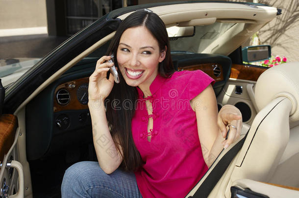 坐在<strong>敞篷</strong>车里用手机的快乐女人