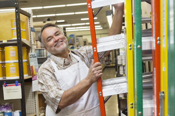 五金店一位快乐的带梯子的成年男子的画像