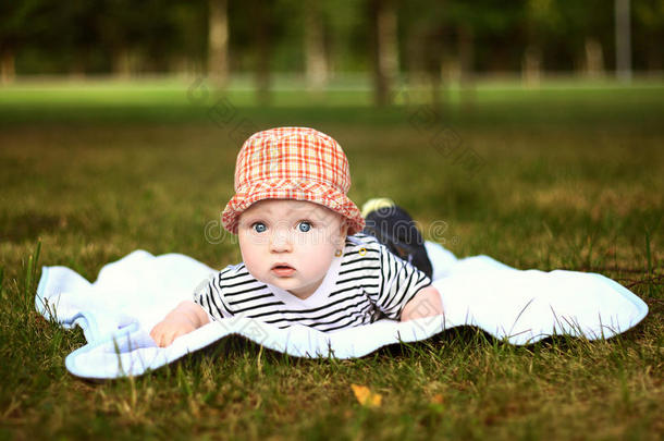 夏日公园里戴着红帽子的可爱小男孩