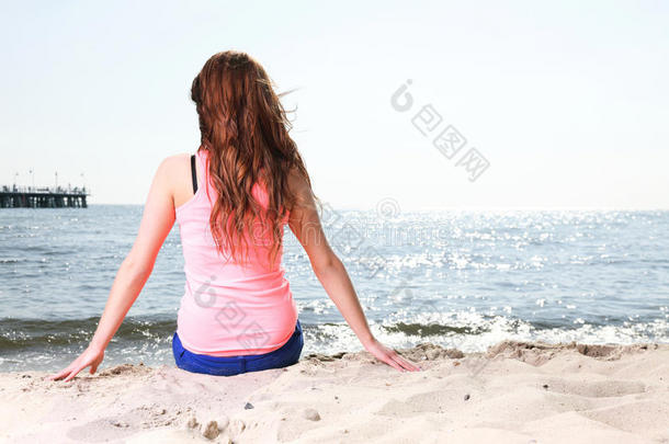 沙滩度假享受夏日阳光的女人坐在沙滩上