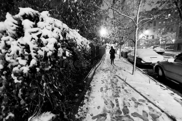 在一个<strong>冰天</strong>雪地的夜晚，一个孤独的女人走在被雪覆盖的哈莱姆街人行道上。