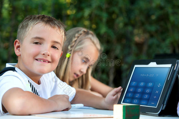 男孩在户外平板电脑上<strong>展示作业</strong>。