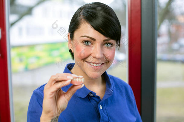 牙科实验室的技术人员向镜头展示假牙