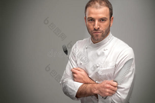 厨师拿着一把大刀和一把叉子