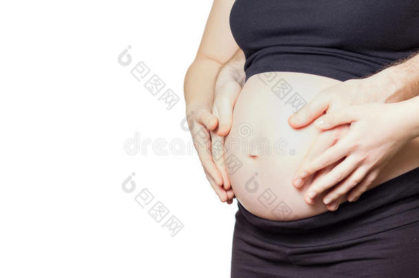 孕妇用手抚摸自己的腹部，丈夫也抚摸