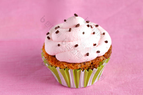带粉红色奶油漩涡和巧克力的纸杯蛋糕