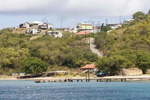海滩、船只、码头和房屋景观；东加勒比海圣文森特和格林纳丁斯马雷岛盐碱湾。