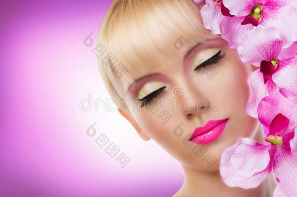 美丽的金发女人带着鲜花和完美的妆容