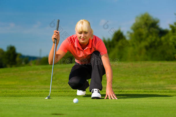 年轻女子高尔夫<strong>选手</strong>在球场上瞄准推杆