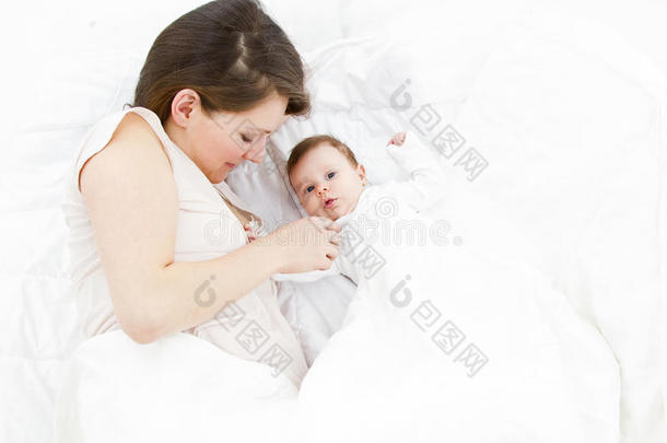 母亲抱着孩子躺在床上