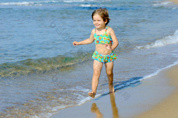 快乐的小女孩在沙滩上奔跑
