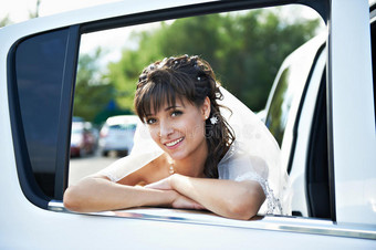 婚礼豪华轿车窗口的快乐新娘图片
