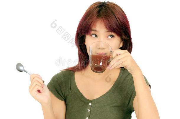 一位年轻的亚洲妇女<strong>端着</strong>一杯咖啡
