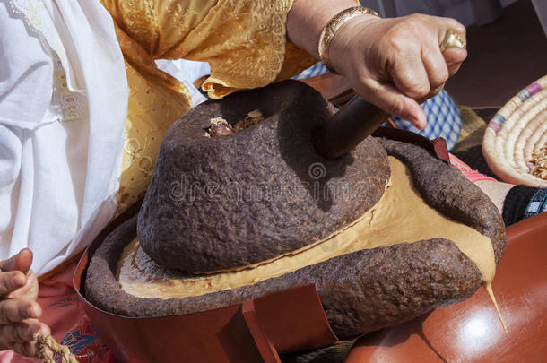 摩洛哥妇女传统上用磨坊磨阿甘果仁