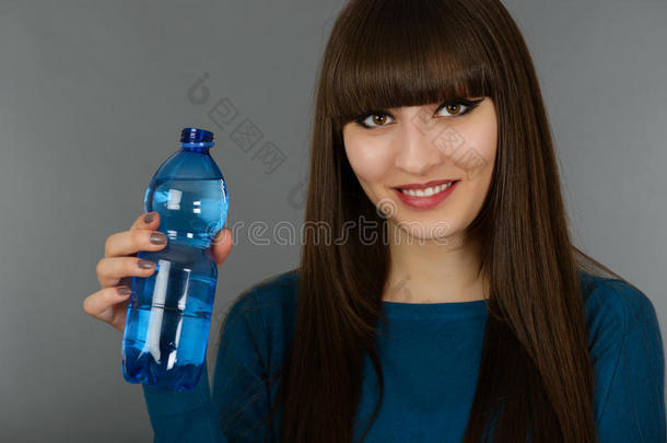 一个女人拿着一瓶<strong>灰白色</strong>的水