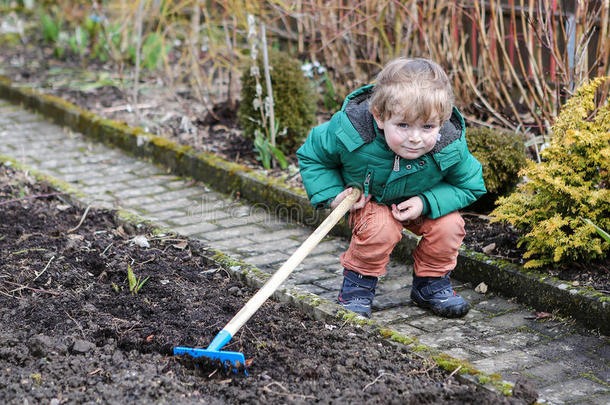 春天的小男孩拿着花园锄头