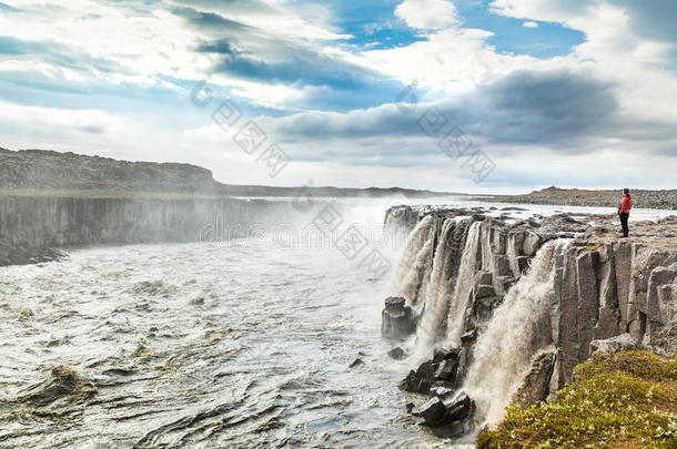 站在冰岛东北部瓦特纳约克尔国家公园著名的塞尔沃斯瀑布附近的妇女