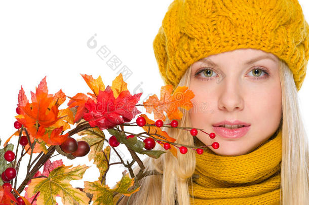 戴着帽子和围巾拿着秋天花束的女孩