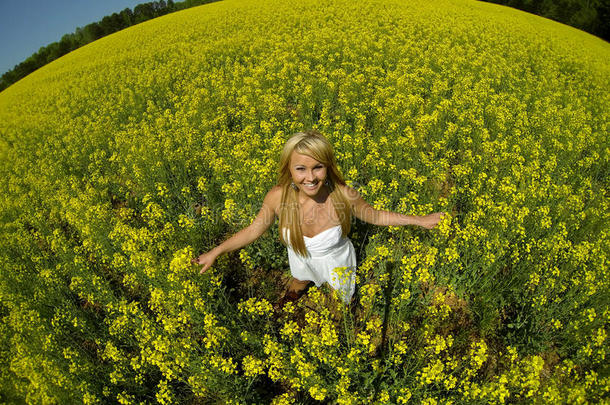 一个美丽的女孩在一片黄色的花丛里